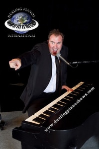 A person passionately playing a grand piano with a microphone.